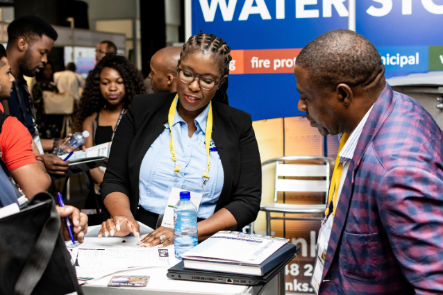 Exhibitor with delegate in exhibition hall